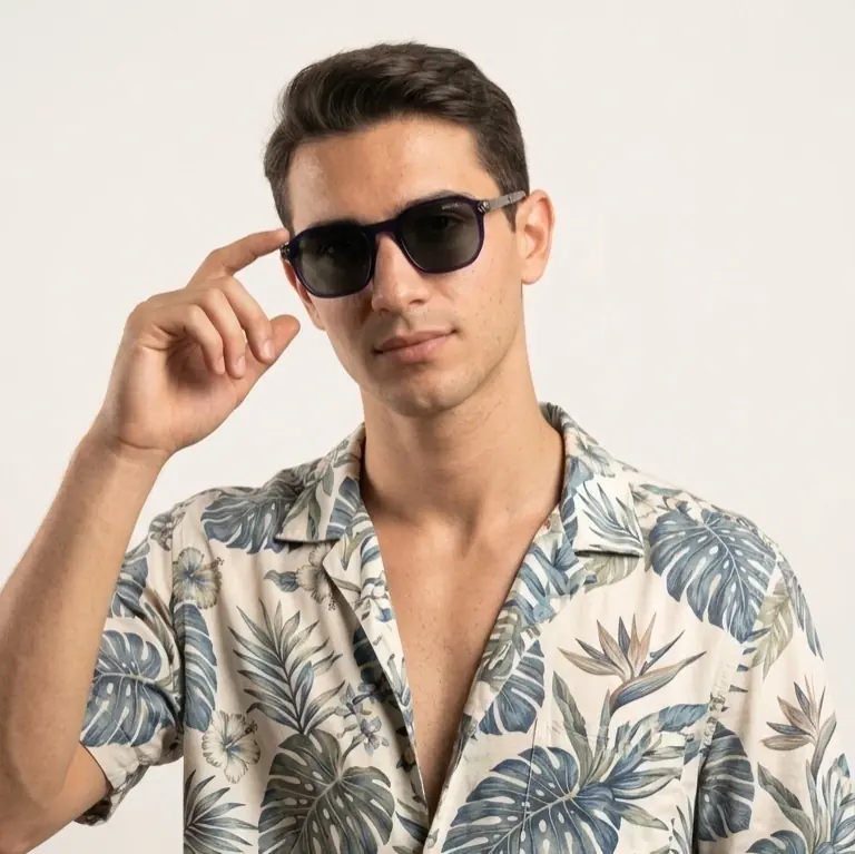 Man in a floral shirt adjusting sunglasses